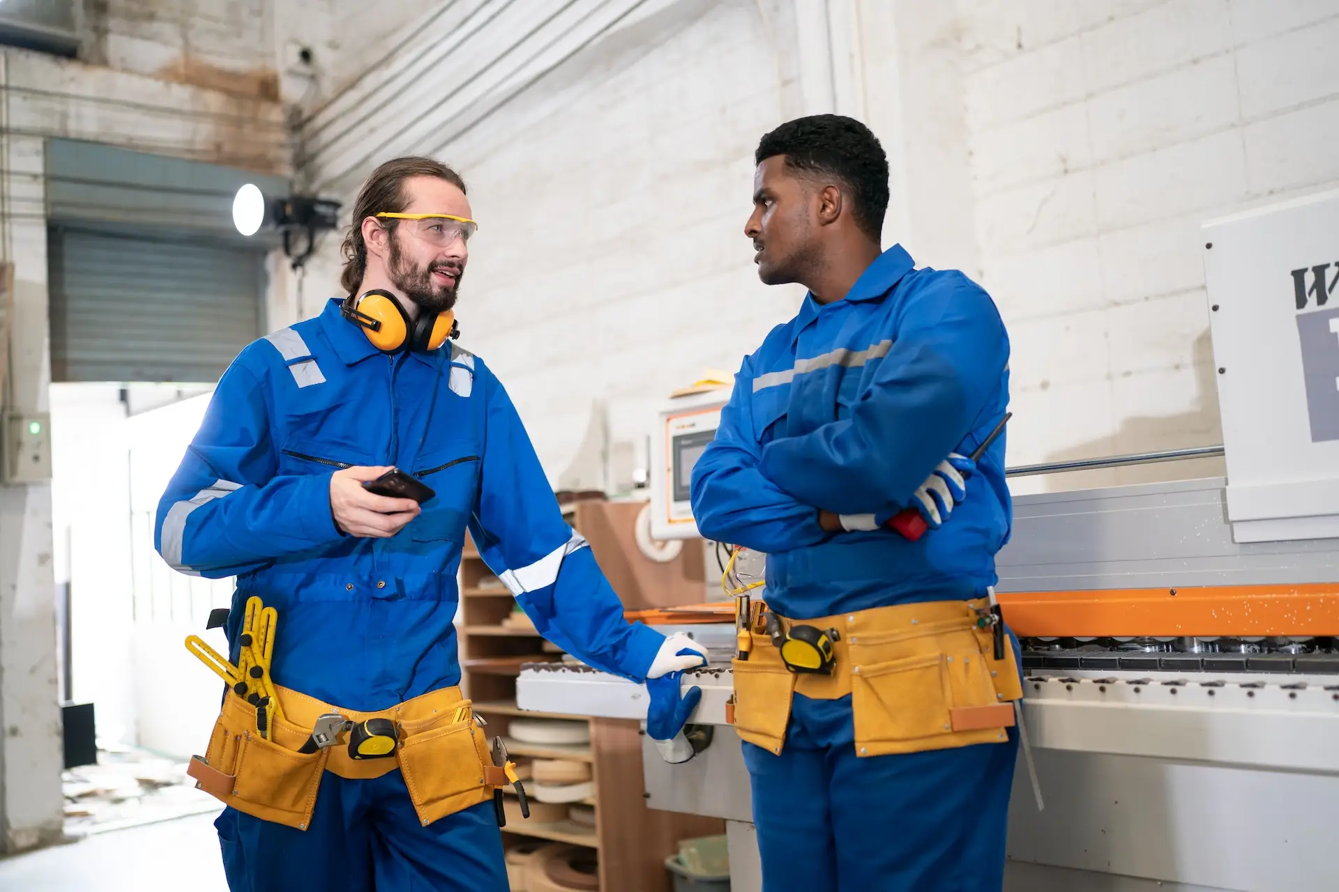 Thumbtack Clone local services marketplace: two skilled tradespeople talking in a workshop.